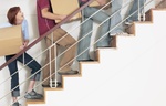Menschen tragen Kartons eine Treppe hinauf
